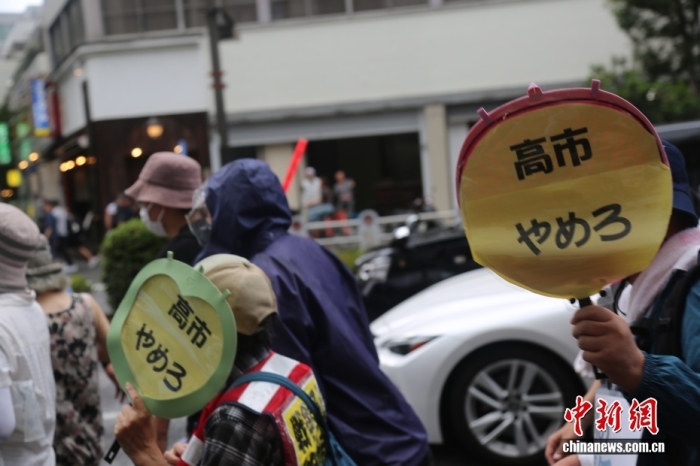 当地时间8月15日，日本民众在东京淡路公园附近举行抗议游行，反对政客向供奉有二战甲级战犯的靖国神社供奉祭祀费或参拜。图为手举“高市下台”标语牌的抗议者。中新社记者 朱晨曦 摄